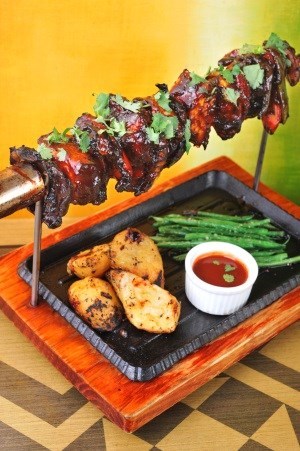 Grilled chicken skewer marinated in ancho chili, orange juice, honey and spices, in “al pastor” style served with roasted lime oregano potatoes